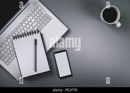 Bureau ordinateur portable gris avec smartphone tasse de café. Vue de dessus with copy space Banque D'Images