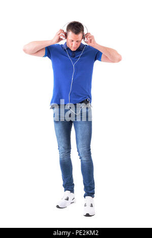 Casual homme adulte de mettre le casque joint au téléphone mobile en poche. Corps plein isolé sur fond blanc. Banque D'Images