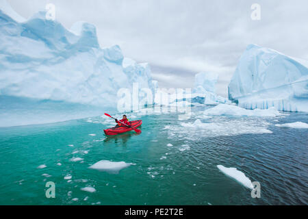 Man paddling kayak sur la glace entre dans Antractica Iceberg en cimetière, kayak d'hiver extrême aventure polaire, près de l'île Pleneau Banque D'Images