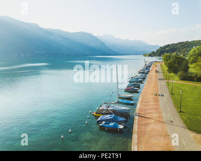 Paysage aérien du lac d'Annecy, Alpes, France, yachts et bateaux à voile à partir de ci-dessus, zone piétonne à pied près de l'eau bleu cristal Banque D'Images