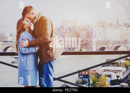 Amour couple dans la rue à Paris, moment romantique en lune de miel, happy young man and woman standing on pont sur Seine Banque D'Images