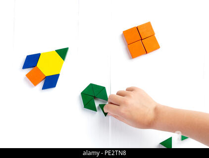 Le navire de l'espace vole dans l'espace pour une autre nouvelle planète. Heureux d'atmosphère. Un enfant joue avec des blocs de couleur construit un modèle sur un parquet en bois clair Banque D'Images