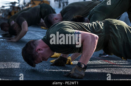 Le Golfe Arabique (sept. 22, 2015) Les Marines américains avec la 15e Marine Expeditionary Unit pushups effectuer dans le poste de pilotage de l'assaut amphibie USS Essex (DG 2). Les marines sont inscrits à un cours de caporaux qui les prépare à être des sous-officiers. La 15e MEU, embarquée à bord des navires du groupe amphibie d'Essex, est déployé pour maintenir la sécurité régionale dans la 5e flotte américaine zone d'opérations. (U.S. Marine Corps photo par le Cpl. De Clerck McKelvey/libérés) Banque D'Images