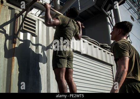 Le Golfe Arabique (sept. 22, 2015) Les Marines américains avec la 15e Marine Expeditionary Unit effectuer tirer-se lève pendant l'entraînement physique sur le poste de pilotage de l'assaut amphibie USS Essex (DG 2). Les marines sont inscrits à un cours de caporaux qui les prépare à être des sous-officiers. La 15e MEU, embarquée à bord de la Essex groupe amphibie, est déployé pour maintenir la sécurité régionale dans la 5e flotte américaine zone d'opérations. (U.S. Marine Corps photo par le Cpl. De Clerck McKelvey/libérés) Banque D'Images