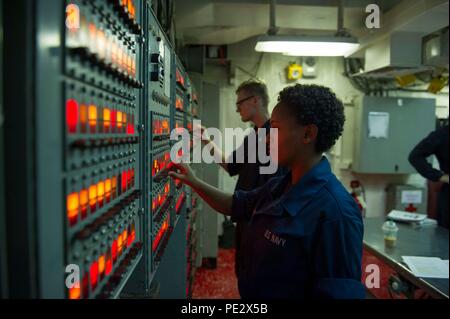 Le Golfe Arabique (sept. 22, 2015) d'un membre de droit, Gebrehiwot Selam, Communications et de l'intérieur 3e classe Électricien Kieran Parker l'essai de diverses opérations d'alarme à bord dans le contrôle des avaries à bord de la classe centrale de guêpe d'assaut amphibie USS Essex (DG 2). Essex est le fleuron de la Essex Groupe amphibie (ARG) et, avec l'entrepris 15e Marine Expeditionary Unit (MEU), est déployé à l'appui d'opérations de sécurité maritime et les efforts de coopération en matière de sécurité dans le théâtre dans la 5e flotte américaine zone d'opérations. (U.S. Photo par marine Spécialiste de la communication de masse 2e classe Molly A. Sonnier/Presse Banque D'Images