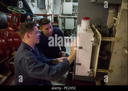 Le Golfe Arabique (sept. 22, 2015) Intérieur électricien en communications 3e classe Alexander Clark, à gauche, et l'Apprenti aviateur James Ryian paramètres du programme sur un système de détection de fuite à bord de la classe Wasp navire d'assaut amphibie USS Essex (DG 2). Essex est le fleuron de la Essex Groupe amphibie (ARG) et, avec l'entrepris 15e Marine Expeditionary Unit (MEU), est déployé à l'appui d'opérations de sécurité maritime et les efforts de coopération en matière de sécurité dans le théâtre dans la 5e flotte américaine zone d'opérations. (U.S. Photo par marine Spécialiste de la communication de masse 2e classe Molly A. Sonnier/libérés) Banque D'Images