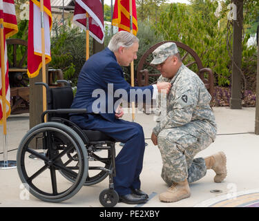 Texas Gov. Greg Abbott awards le Texas Purple Heart pour le s.. Guadalupe Chapa, lors d'une cérémonie qui a eu lieu au Fort Sam Houston à San Antonio, le 24 septembre, 2015. Chapa et trois autres gardes nationaux du Texas ont été déployés avec le 1er escadron, 112e régiment de cavalerie, qui faisait partie de la Force multinationale et Observateurs (FMO) mission en Egypte, quand ils ont reçu leurs blessures. (U.S. La Garde nationale de l'armée photo par le Sgt. 1re classe Malcolm McClendon) Banque D'Images