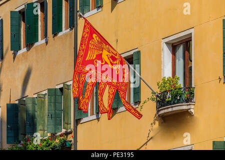 Drapeau vénitien traditionnel avec le Lion de Saint Marc sur une façade de l'immeuble à Venise, Italie Banque D'Images