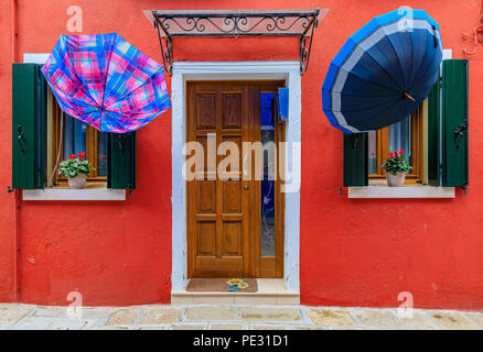 Des maisons pittoresques et colorées avec des parasols étendus dehors dans l'île de Murano près de Venise en Italie, qui est connu pour dentelle. Banque D'Images