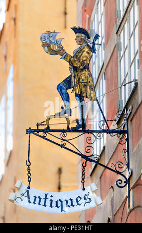 Stockholm, Suède - le 14 août 2017 : Ancien style de métal forgé antique store signe représentant un homme vêtu de vêtements vintage avec un bateau jouet en hi Banque D'Images