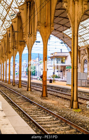 Train vide les voies et les colonnes robustes à la gare de Nice, France sur un matin tôt Banque D'Images