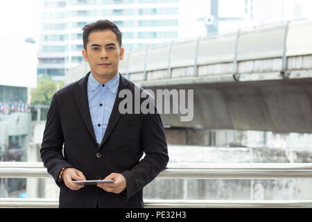 Happy businessman standing on walkway of building Banque D'Images