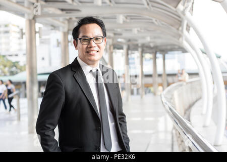 Happy businessman standing on walkway of building Banque D'Images