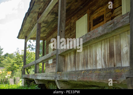 Ancienne maison rurale en bois dans une zone montagneuse dans les Carpates. Bâtiment traditionnel. Cour avec l'herbe verte. Banque D'Images