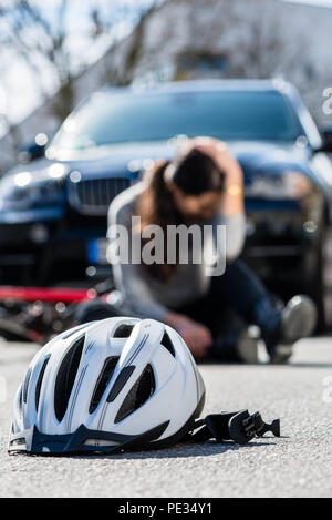 Casque de vélo sur l'asphalte après une collision Banque D'Images