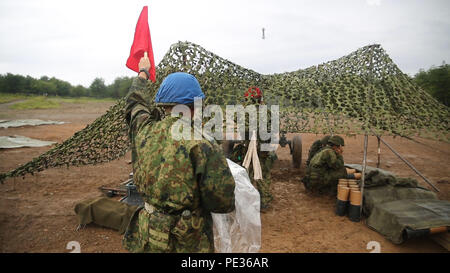 Un membre de la Force d'autodéfense japonaise contient jusqu'un drapeau montrant qu'ils sont sur le point de tirer un mortier de 120 mm pendant la Lumière forestière 16-1 au Camp Imazu, Takashima, le Japon, le 6 septembre 2015. La JGSDF et Marines des États-Unis ont pris le relais des missions de tir d'appel, préparation du mortier pour le feu, et le tir de mortier. Feu de forêt est une semi-annuel, exercice bilatéral composé d'un exercice de poste de commandement et de multiples événements de formation de terrain menées par des éléments de III Marine Expeditionary Force et la JGSDF. La JGSDF vient du 50e Régiment d'infanterie, 14e Brigade. (U.S. Marine Corps Photo par le Cpl. Tindle Devon/Re Banque D'Images