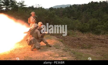 Le Cpl. Brandon Crain hurle à incendie Lance Cpl. Clayton Baker tout en démontrant les capacités de l'arme d'assaut polyvalent lancé à l'autodéfense japonaise pendant la Lumière forestière 16-1 au Camp Imazu, Takashima, le Japon, le 7 septembre 2015. La JGSDF et Marines des États-Unis se relayaient pour le partage des connaissances sur les différents systèmes de missiles anti-char. Après avoir donné les caractéristiques de leurs systèmes d'armes, les deux forces d'exercice utilisé pour démontrer comment les systèmes d'armes. Feu de forêt aura lieu du 7 au 18 septembre, avec environ 240 Marines américains travaillant à côté de 35 Banque D'Images