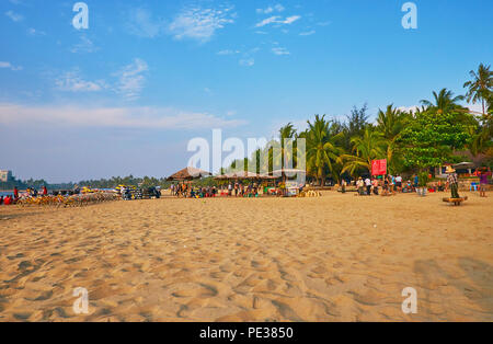 CHAUNG THA, LE MYANMAR - 28 février 2018 : Panorama de la plage de sable avec des vendeurs de rue, rangée de palmiers verts et point de location de vélo, sur Février Banque D'Images