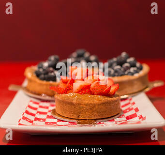 Tarte aux fraises avec tartes aux bleuets en arrière-plan. Banque D'Images