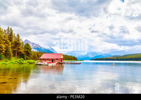 Canoës colorés se trouvent sur le quai à bateaux au Lac Maligne dans le parc national Jasper, Alberta, Canada. Le lac est connu pour les sommets environnants et Banque D'Images