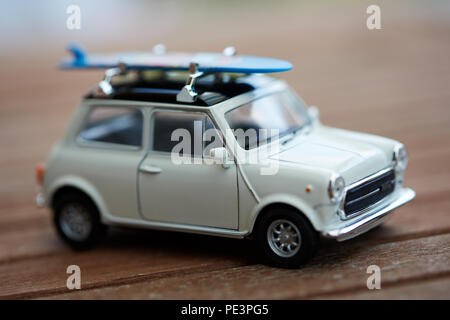 Mini voiture jouet avec sufboard sur le toit du prince pour des vacances sur la plage Banque D'Images