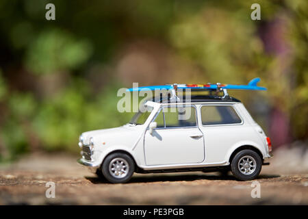 Mini voiture jouet avec sufboard sur le toit du prince pour des vacances sur la plage Banque D'Images