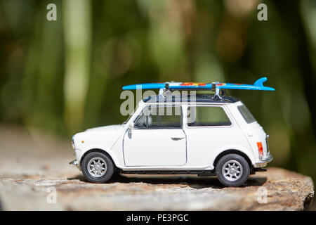 Mini voiture jouet avec sufboard sur le toit du prince pour des vacances sur la plage Banque D'Images