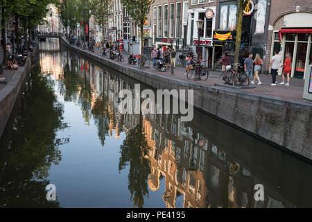 Amsterdam, Pays-Bas - Août 2018 : Reflets dans le canal du quartier rouge au coucher du soleil à Amsterdam Banque D'Images