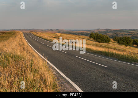 Une lande déserte Staffordshire road dans le parc national de Peak District sur une chaude soirée de juillet avec des lignes diagonales, England, UK Banque D'Images