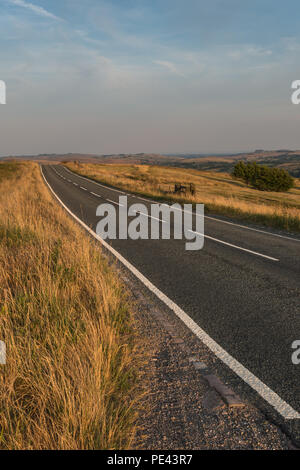 Une lande déserte Staffordshire road dans le parc national de Peak District sur une chaude soirée de juillet avec des lignes diagonales, England, UK Banque D'Images