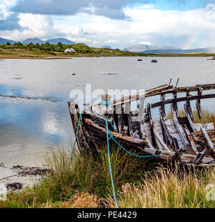 Proue d'un bateau cassé avec douze Bens au-delà de l'île si Inishnee près de Roundstone sur la côte du Connemara en Irlande Banque D'Images