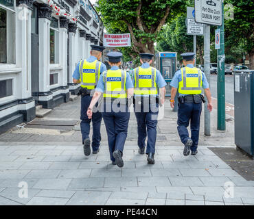 Quatre agents de garde en hi-viz vestes en passant devant un pub à Dublin le jour de match dans la République d'Irlande Banque D'Images