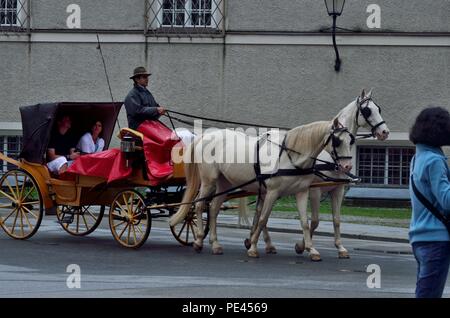 Une voiturette à cheval avec passagers, en traversant la célèbre cathédrale de Salzbourg, Autriche, Europe Banque D'Images