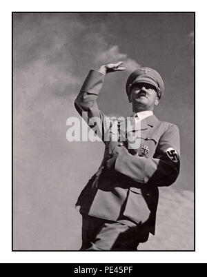 ADOLF HITLER SALUTE 1939 WW2 de la propagande allemande de droit d'Adolf Hitler en uniforme militaire portant un brassard à croix gammée nazie saluant "Heil Hitler" à une foule low angle view avec le fond de ciel Banque D'Images