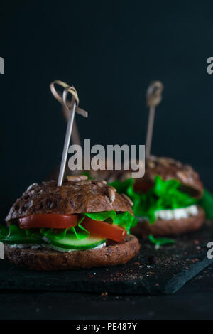 Sandwich avec salade verte, tomates, concombres et fromage à la crème sur le béton 24. Banque D'Images