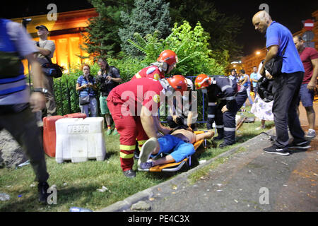 Bucarest, Roumanie - 10 août 2018 : Les ambulanciers offrent les premiers soins aux blessés un supporteur de football par des gaz lacrymogènes reçoit lors de la violente anti- Banque D'Images