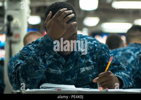 150917-N-DA737-027 Bremerton, dans l'État (sept. 17, 2015) - Communications intérieures matelot Électricien Quadrel Carrington, de New York, à l'échelle de la Marine prend l'examen de l'avancement sur l'USS JOHN C. STENNIS (CVN 74) ponts mess avant. La Marine propose des candidats admissibles les deux occasions par année, au printemps et à l'automne, à tester pour la prochaine année d'une rémunération plus élevée. L'équipage Stennis est en ce moment à port la formation de futurs déploiements. (U.S. Photo par marine Spécialiste de la communication de masse de la classe 3ème Jonathan Jiang / relâché) Banque D'Images