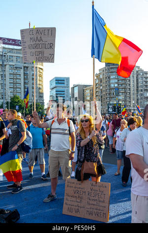 Bucarest, Roumanie - 10 août 2018 : un jeune couple de bannières en montrant la Diaspora protester contre la manière dont la Roumanie est régie par les sociaux-démocrates Banque D'Images