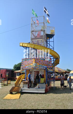 Un pêle-mêle children's ride à la fête foraine dans l'heure d'été à Churston, Devon, Angleterre, Royaume-Uni. Banque D'Images