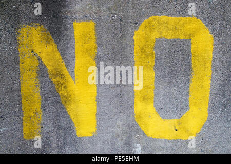 Le mot non peint en jaune sur un mur de béton gris. Banque D'Images