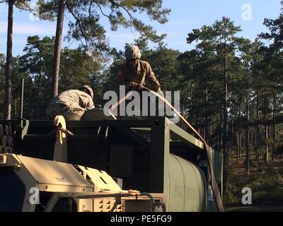 Les soldats du 127e et la 226e QM Offre Composite Company travailler ensemble pour remplir un hippopotame M105 au cours de la distribution. Groupe de travail de l'eau a émis l'eau purifiée à 26 sites de distribution, y compris sept restaurants, trois franchises de restauration AAFES, trois centres de développement de l'enfant, deux écoles élémentaires et un hôpital. Banque D'Images