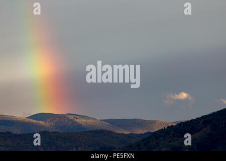 Belle et surréaliste vue d'une partie d'un arc-en-ciel sur certaines collines Banque D'Images