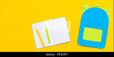 Sac à dos sac d'école, cahiers et crayons papier découpées sur fond jaune Banque D'Images
