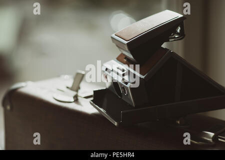 Appareil photo instantané Vintage sur une vieille valise avec un cadenas ouvert Banque D'Images