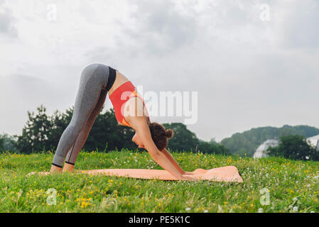 Curly Slim woman standing in bas posent sur l'herbe verte Banque D'Images