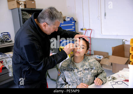 Le 23 septembre 2015, un paramédical allemand de la Croix-Rouge a appliqué un maquillage de moulage pour simuler des blessures sur un médecin de l'armée américaine de la 529e compagnie de police militaire lors d'un cours international de sauvetage de combat à Dragon's Lair, Clay Kaserne, Wiesbaden, Allemagne. La formation comprenait des simulations de victimes, des procédures médicales, des opérations urbaines et la coordination entre les forces multinationales afin d'améliorer les compétences et la préparation au combat pour sauver des vies. Banque D'Images