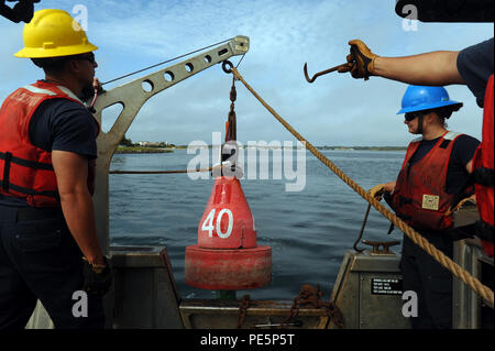 Les membres de l'équipage de la Garde côtière de l'équipe d'aides à la navigation New York préparer pour abaisser une bouée le long de la rivière de Shrewsbury dans le New Jersey, le 29 septembre, 2015. Les hommes et les femmes de New York ANT sont responsables de l'entretien, 96 480 aides principales aides saisonnières et 9 phares majeurs, ce qui permet de garantir la sécurité du transport maritime dans la région. (U.S. Photo de la Garde côtière canadienne par le maître de 3e classe Ali Flockerzi.) Banque D'Images