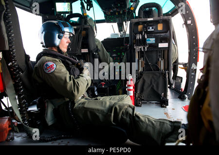 Le 29 septembre 2015, au-dessus de la baie de Galveston, au Texas, un hélicoptère MH-65 Dolphin de la Garde côtière américaine effectue une formation sur les opérations de nuit. L'hélicoptère bimoteur de récupération à courte portée utilise des moteurs Turbomeca Arriel 2C2-CG. Les équipages aériens pratiquent des missions de sauvetage en basse lumière avec des opérations de levage, se préparent à la récupération du personnel, à la sécurité maritime et aux tâches de recherche et sauvetage tout en maintenant la disponibilité opérationnelle dans des conditions de visibilité limitée. Banque D'Images