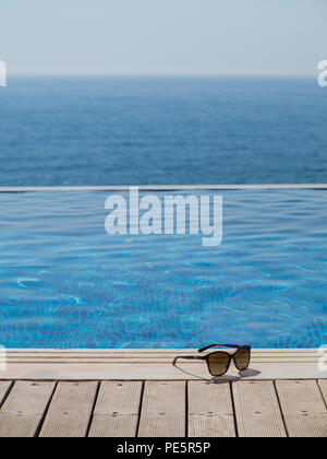 Lunettes de soleil en bois d'une piscine à débordement Banque D'Images