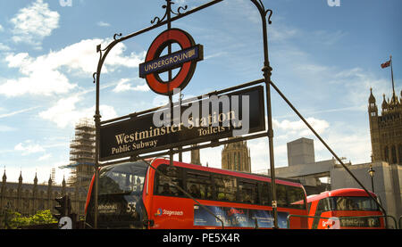 Signe au-dessus de l'entrée de la station de métro de Westminster à Londres, avec des bus de Londres rouge fond il int Banque D'Images